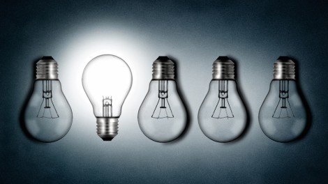 Illuminated lightbulb amid dim bulbs - creativity and innovation concept